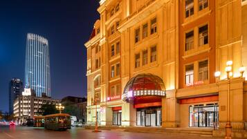 A hotel with a prominent dome entrance, a red awning, and a sign reading 'IBIS HOTEL.'