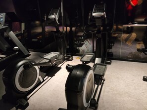 Ein stationäres Fahrrad mit digitalem Display, Gewichtsstapel und Fußpedal.