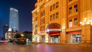 A hotel with a prominent dome entrance, a red awning, and a sign reading 'IBIS HOTEL.' - Ibis Hotel Tianjin Railway Station Jinwan Plaza (Tianjin)