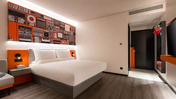 Quarto de hotel moderno com uma cama grande, televisão na parede e uma composição artística original.