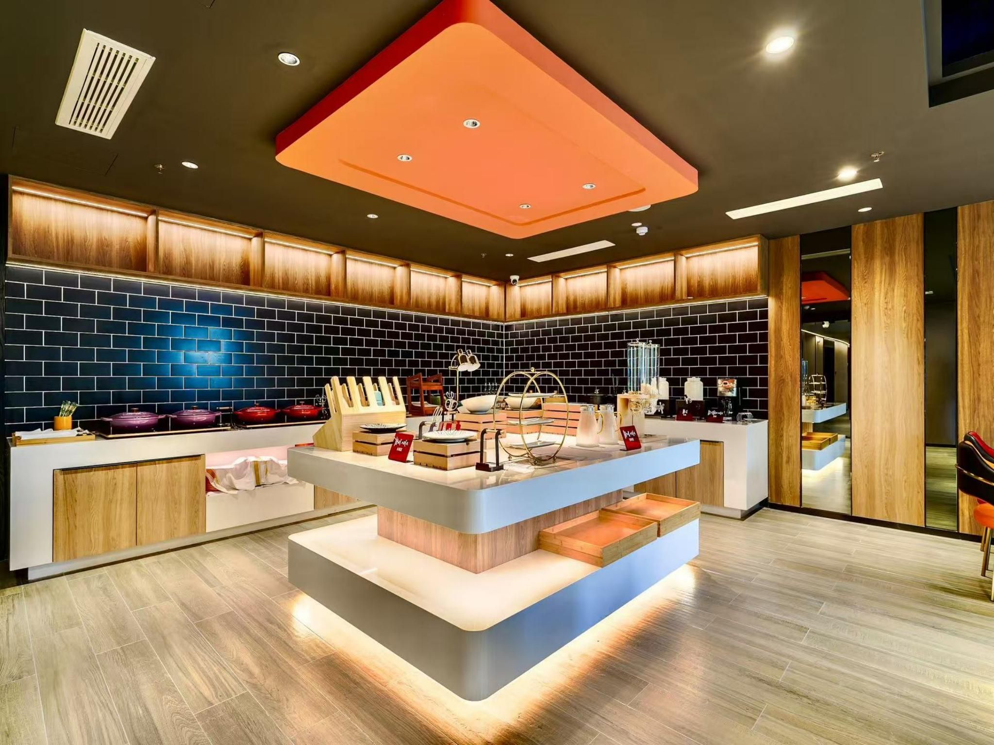 Una cocina moderna con una isla central, armarios de madera y un salpicadero de azulejos negros.