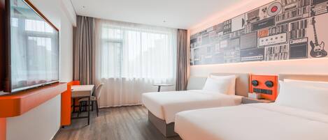 Habitación de hotel con dos camas, televisor, escritorio y una pared con equipo musical.