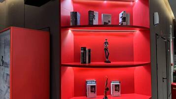 A red shelving unit with books and a small statue.