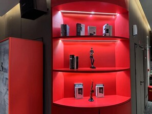 A red shelving unit with books and a small statue. - Ibis Qingdao Xinduxin Capitamall Hotel (Qingdao)