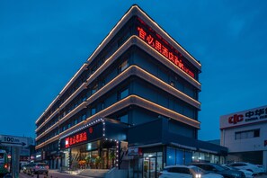 A multi-story hotel with a prominent signage indicating it is a China Inn. - Ibis Qingdao Xinduxin Capitamall Hotel (Qingdao)