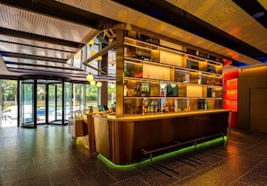 A bar area with a counter, shelves with bottles, and a glass door entrance. - Ibis Qingdao Xinduxin Capitamall Hotel (Qingdao)