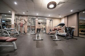 A gym with various exercise equipment, including weight machines, a treadmill, and a stationary bike. - Hotel Iceberg (Sofia)