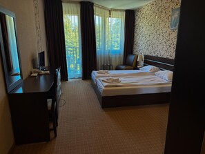 A hotel room with a bed, a desk, a chair, and a TV. - Hotel Iceberg (Sofia)