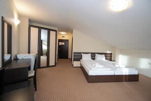 A hotel room with a bed, a desk, a chair, a mirror, and a door. - Hotel Iceberg (Sofia)