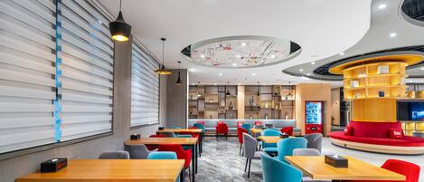 A modern restaurant with a central seating area, individual tables, and a distinctive circular ceiling design.