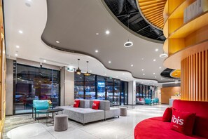 A modern hotel lobby with seating areas, a reception desk, and large windows offering views of the outside. - Ibis Hotel Foshan Shunde Jing Long Subway Station (Foshan)