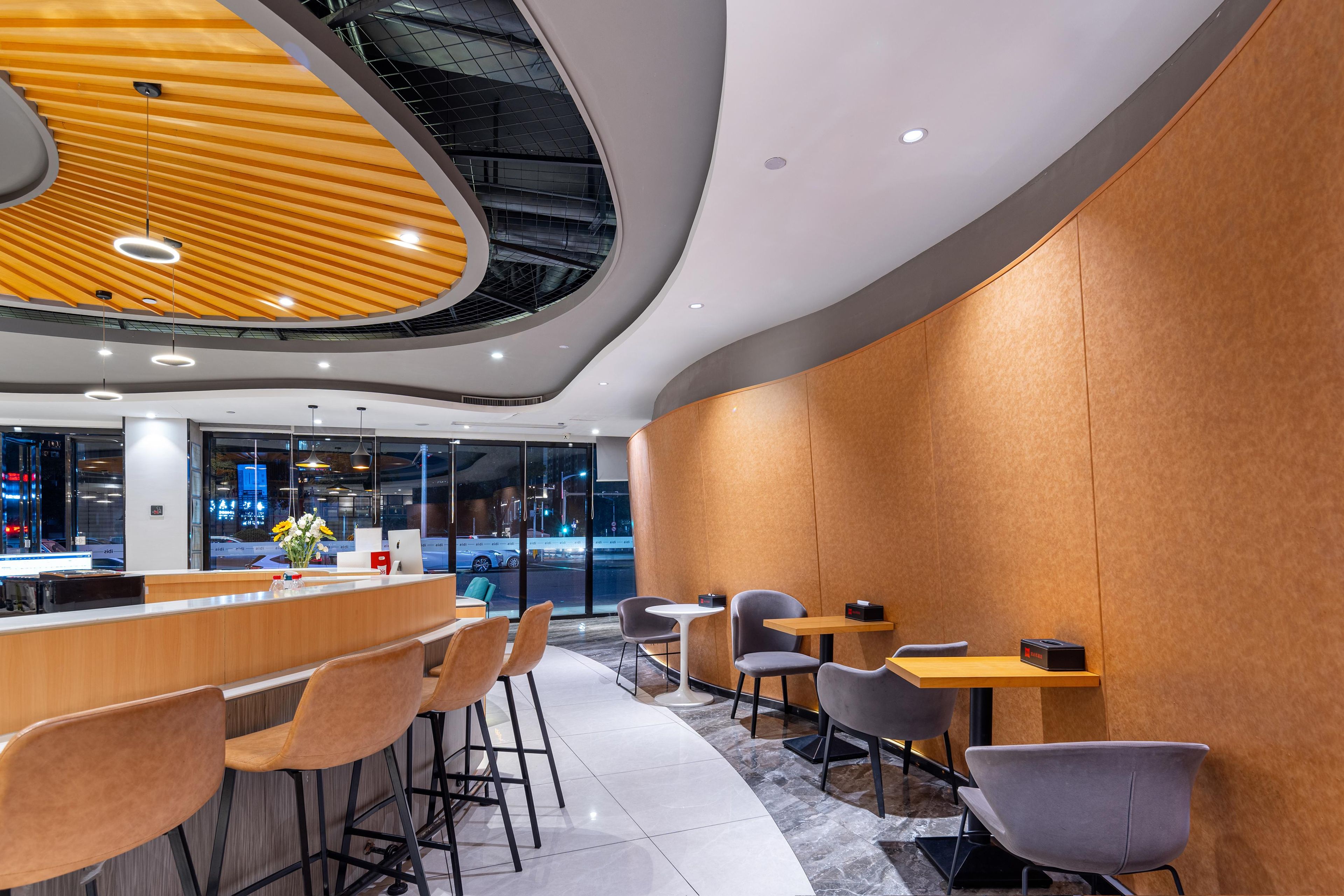 A modern interior with a curved wooden ceiling, bar area, and seating.