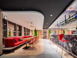 A modern restaurant with red seating, wooden tables, and a green wall. - Ibis Chengdu Kuanzhai Alley Center Hotel (Chengdu)