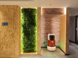 A hallway with a vertical garden, a wall-mounted heater, and a sign indicating a fire extinguisher. - Ibis Chengdu Kuanzhai Alley Center Hotel (Chengdu)