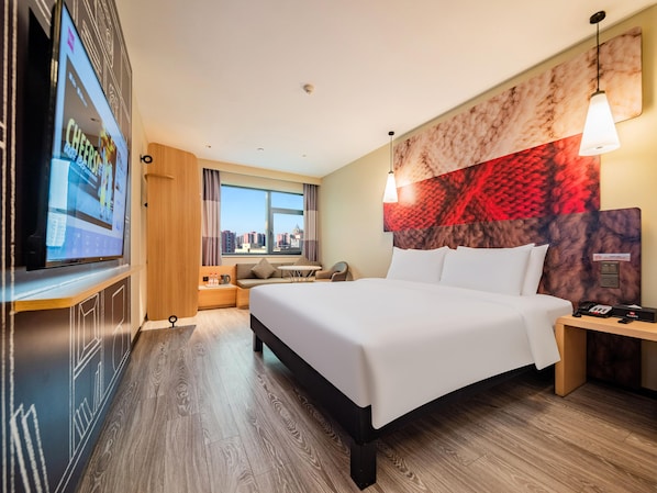 A hotel room with a large bed, a TV on the wall, a city view, and a modern headboard. - Ibis Chengdu Kuanzhai Alley Center Hotel (Chengdu)