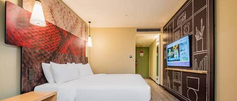 Ein modernes Hotelzimmer mit einem großen Bett, Nachttisch, Wand-TV und einem einzigartigen Kunstwerk an der Wand.