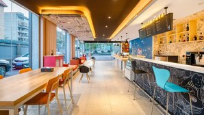 A modern bar area with a menu board, seating, and a view of the street. - Ibis Chengdu Kuanzhai Alley Center Hotel (Chengdu)