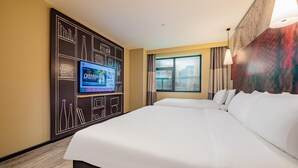 A hotel room with a large bed, a flat-screen TV mounted on a black wall, a window with curtains, and a city view. - Ibis Chengdu Kuanzhai Alley Center Hotel (Chengdu)