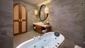 A modern bathroom with a freestanding bathtub, a vanity with a mirror, and a wooden door. - Asvara Luxury Resort Ubud By Ini Vie hospitality (Payangan)