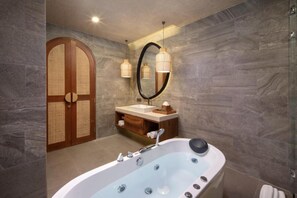 A modern bathroom with a freestanding bathtub, a vanity with a mirror, and a wooden door. - Asvara Luxury Resort Ubud By Ini Vie hospitality (Payangan)