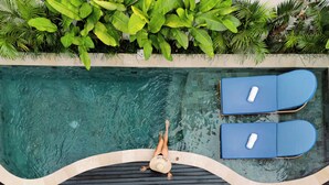 A swimming pool with two lounge chairs, surrounded by lush greenery. - Asvara Luxury Resort Ubud By Ini Vie hospitality (Payangan)