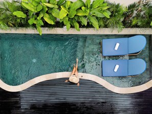 A swimming pool with two lounge chairs, surrounded by lush greenery. - Asvara Luxury Resort Ubud By Ini Vie hospitality (Payangan)