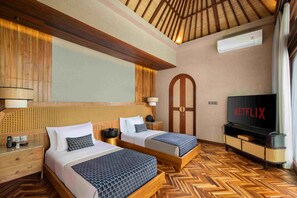 A hotel room with two beds, a television, and a wooden ceiling. - Asvara Luxury Resort Ubud By Ini Vie hospitality (Payangan)