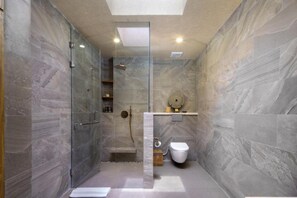 A modern bathroom with a glass-enclosed shower, a toilet, and a marble wall. - Asvara Luxury Resort Ubud By Ini Vie hospitality (Payangan)