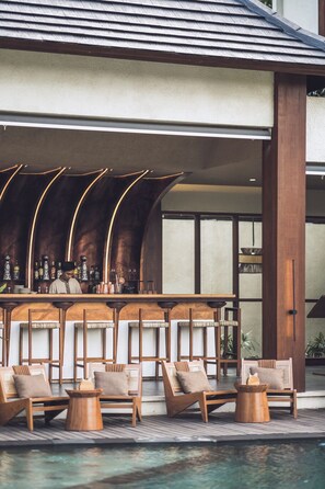 A poolside bar area with wooden chairs and a bar counter. - Asvara Luxury Resort Ubud By Ini Vie hospitality (Payangan)