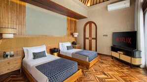 A hotel room with two beds, a television, and a wooden ceiling. - Asvara Luxury Resort Ubud By Ini Vie hospitality (Payangan)