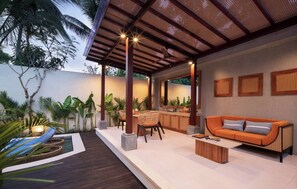 Eine Außenpatio mit Holzdeck, einer Couch, Sesseln und einem kleinen Pool.