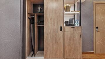 Un meuble de rangement moderne doté d’une porte coulissante, d’une étagère sur laquelle est posé un vase, et d’une machine à café.