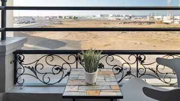 A balcony with a potted plant, a stone table, and a metal railing.