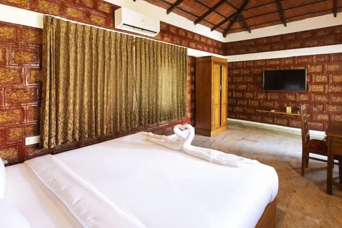 Una habitación de hotel con una cama grande, un escritorio, una silla y un televisor.