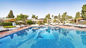 A swimming pool with lounge chairs, palm trees, and resort-style buildings. - Maspalomas Villas By Dunas (San Bartolomé de Tirajana)