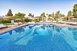 A swimming pool with lounge chairs, palm trees, and resort-style buildings. - Maspalomas Villas By Dunas (San Bartolomé de Tirajana)