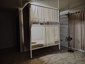 A bunk bed with a ladder, a power outlet, and a fan on the floor. - Casa Club Bluaska (Las Horquetas)