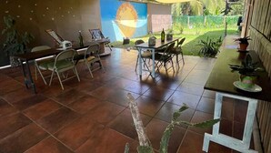 A spacious room with a large window, a dining area with chairs and a table, and a wall with a mural. - Casa Club Bluaska (Las Horquetas)