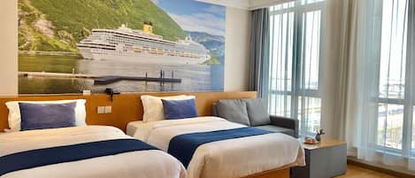 A hotel room with two beds, a large window with curtains, and a mural of a cruise ship.