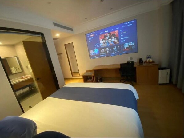 A hotel room with a bed, a desk, a television mounted on the wall, and a door leading to a bathroom. - Linjiang International Cruise Hotel (Shanghai)