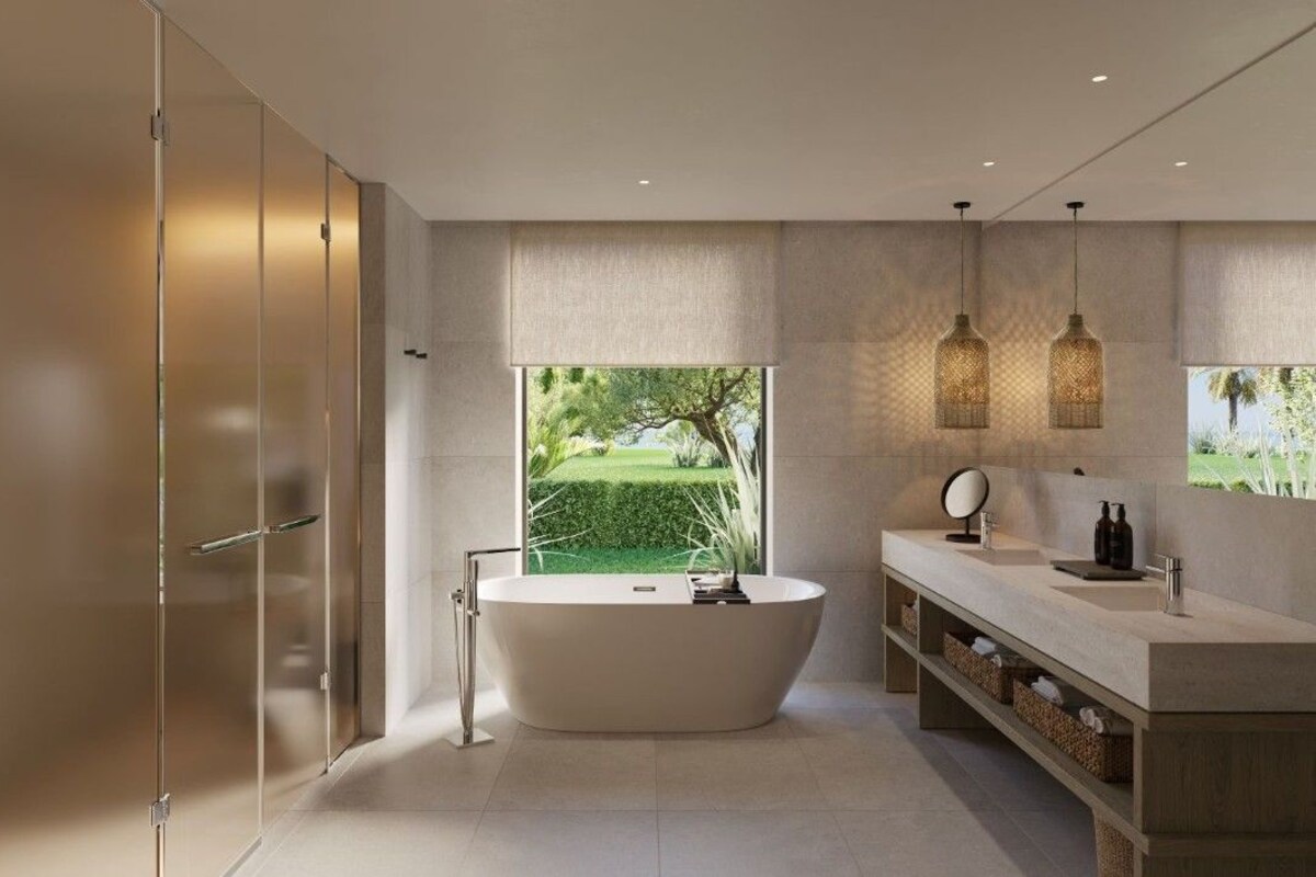 A modern bathroom with a freestanding bathtub, a vanity with a mirror, and a large window offering a view of a garden.