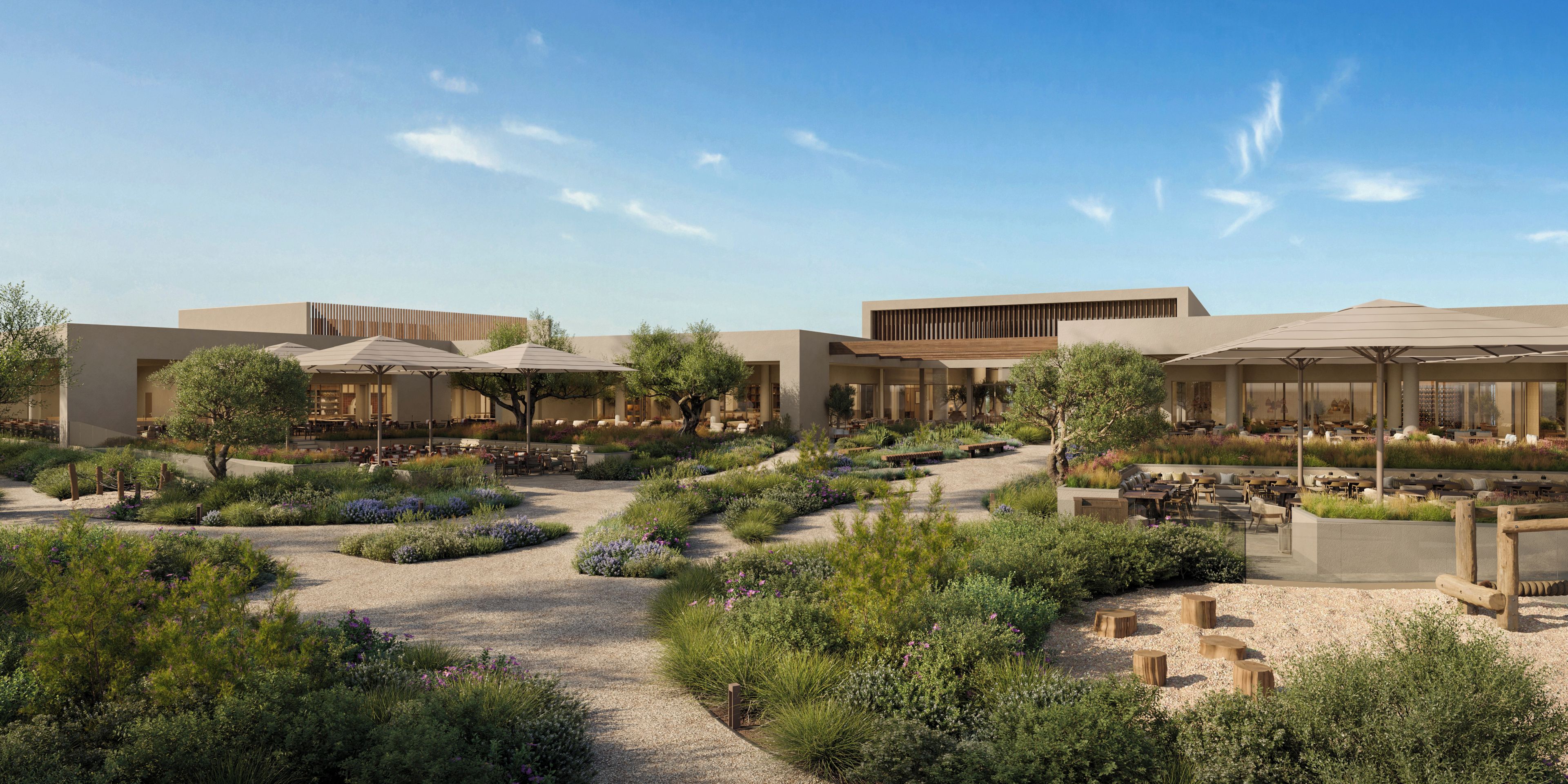 A modern building with outdoor seating areas, surrounded by landscaped gardens and pathways.