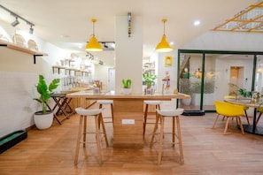 Una cocina moderna con taburetes de madera, iluminación colgante y plantas en macetas.
