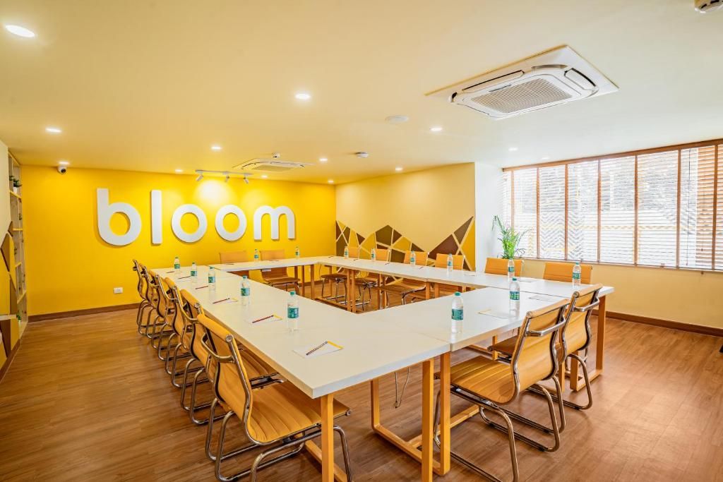 A conference room with a long table, chairs, and a 'bloom' sign on the wall.