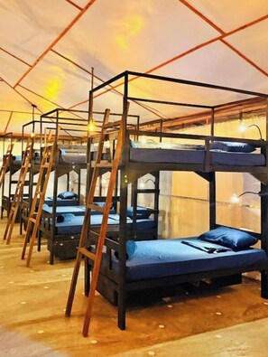 A series of bunk beds with wooden frames and ladders, arranged in a row under a tent-like structure. - The Calm Of8 Arugambay (Arugam Bay)