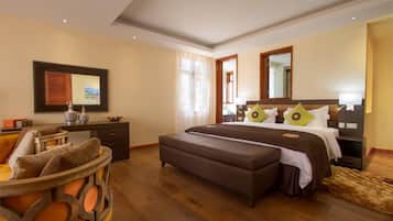 A bedroom with a bed, a desk, a chair, and a large mirror.
