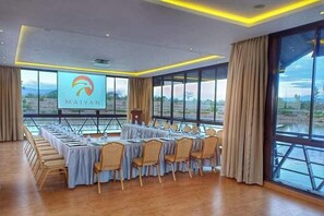 A conference room with a long table, chairs, a podium, and a large screen displaying the 'MAIYAN' logo. - Maiyan Resort (Nanyuki)