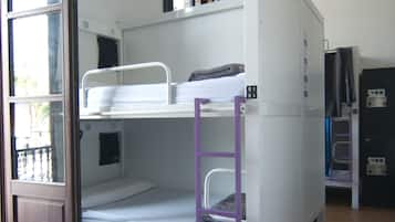 Uma cama beliche com uma cama inferior, uma escada roxa e uma janela.