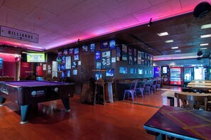A billiards room with multiple tables, chairs, and a pool table. - Kabul Party Hostel (Barcelona)