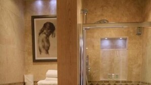 A bathroom with a glass-enclosed shower, a toilet, and a framed picture on the wall. - Woodman Inn (Bedale)